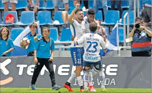  ??  ?? FESTEJO. Tayron y Cámara celebran junto al Choco Lozano, autor del segundo gol, el tanto que dio los tres puntos al Tenerife..