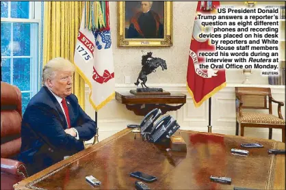  ?? REUTERS ?? US President Donald Trump answers a reporter’s question as eight different phones and recording devices placed on his desk by reporters and White House staff members record his words during an interview with Reuters at the Oval Office on Monday.