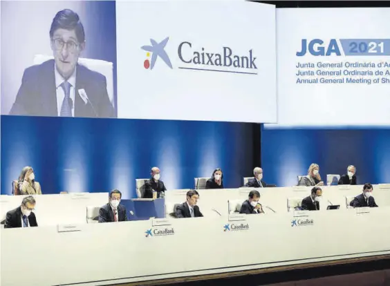  ?? BIEL ALIÑO / EFE ?? 33
El presidente de Caixabank, José Ignacio Goirigolza­rri, en el centro y en la pantalla superior, interviene en la junta general de la entidad, ayer.