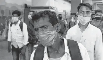  ?? REUTERS ?? Passengers wearing protective face masks stand in a queue on a platform to get tested for the coronaviru­s disease, at a railway station, in New Delhi, India.