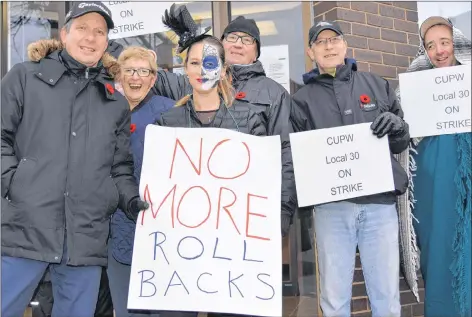  ?? TERRENCE MCEACHERN/THE GUARDIAN ?? Canada Post workers are shown on the picket line in front of the outlet at the corner of Queen and Kent streets in Charlottet­own on Wednesday morning.