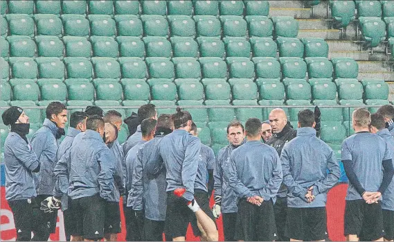  ?? FOTO: AP ?? Zidane charla con sus jugadores en la sesión de ayer en el Estadio del Ejército Polaco Las gradas estarán hoy vacías en un duelo rodeado de grandes medidas de seguridad