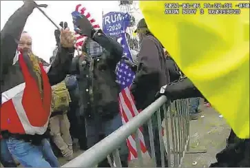  ?? Metropolit­an Police Department ?? BODY-CAMERA video in the case against former New York Police Officer Thomas Webster, in red jacket, shows him charging a barricade, swinging at a police officer with a flagpole and scuffling with the officer.