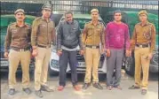  ?? SOURCED ?? The astrologer (in red sweater) and his associate. Police recovered four stolen cars (behind the group) from the men.