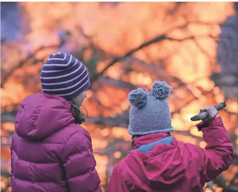  ?? FOTO: DPA ?? Zwei Mädchen vor einem Osterfeuer. Den Brauch soll es wegen Corona in diesem Jahr nicht geben.