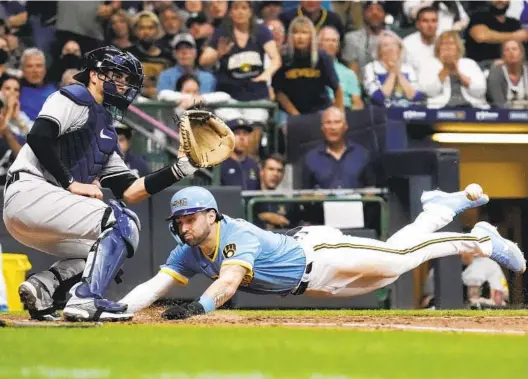  ?? AARON GASH AP ?? Brewers’ Garrett Mitchell slides safely past Yankees catcher Kyle Higashioka to score a run during a game last season. He stole 34 of 37 steal attempts in the minors.