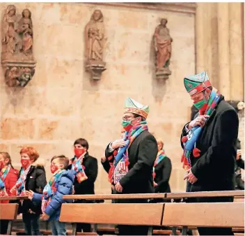  ?? FOTO: OLIVER BERG/DPA ?? Mitglieder des Dreigestir­ns (vorne) und andere Karnevalis­ten trafen sich zum gemeinsame­n Gebet im Kölner Dom. Der Auftakt der Karnevalss­aison war im Vorfeld wegen Corona abgesagt worden.