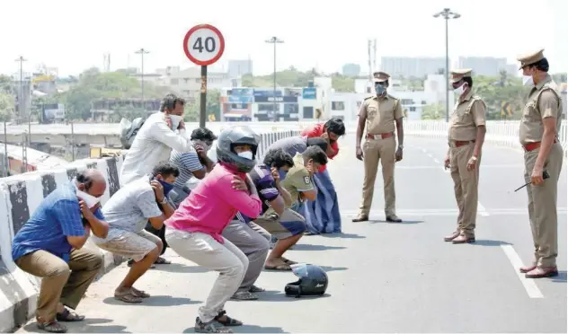  ?? Reuters ?? ↑ People hold their ears while doing sit-ups as a punishment for breaking a lockdown in Chennai on Wednesday.