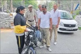  ?? HT PHOTO ?? A police inspector issuing a challan to a policeman found driving without wearing a helmet in Rohtak on Friday.