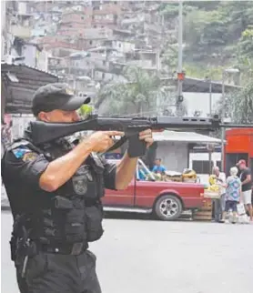  ??  ?? Policial militar de prontidão num dos acessos à Favela da Rocinha