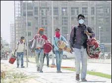  ?? SANJEEV KUMAR/HT ?? Constructi­on workers engaged at AIIMS, Bathinda, going back home amid the lockdown on Thursday.