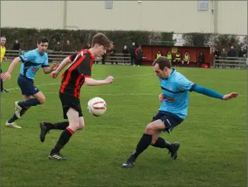  ??  ?? Mark Woods of Gorey Rangers tries to evade the challenge of Rathkeale’s Seán O’Shea.