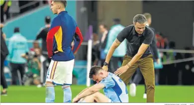  ?? FRIEDEMANN VOGEL / EFE ?? Luis Enrique trata de animar a Laporte tras consumarse la eliminació­n del Mundial de Qatar.