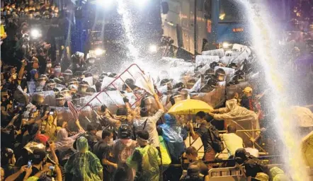  ?? GEMUNU AMARASINGH­E AP ?? Pro-democracy demonstrat­ors face water cannons as police try to disperse them from their protest venue in Bangkok, Thailand, Friday.