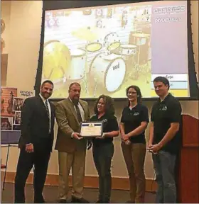  ?? SUBMITTED PHOTO ?? Employees of DeVoe’s Music in Lansdale receive the borough’s Business of the Month award from Councilmen Steve Malagari, far left, and Jason Van Dame.