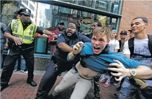  ?? MICHAEL DWYER/THE ASSOCIATED PRESS ?? A counterpro­tester, part of a small group who remained on the street hours after a ‘free speech’ rally was staged by conservati­ve activists, scuffles Saturday with a security guard and police in Boston.