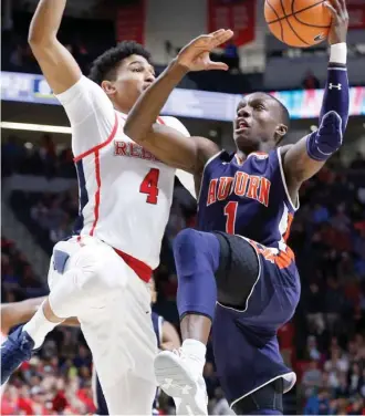  ?? (Photo by Rogelio V. Solis, AP) ?? Auburn guard Jared Harper (1) attempts a layup past Ole Miss guard Breein Tyree during the first half of a game earlier this season.