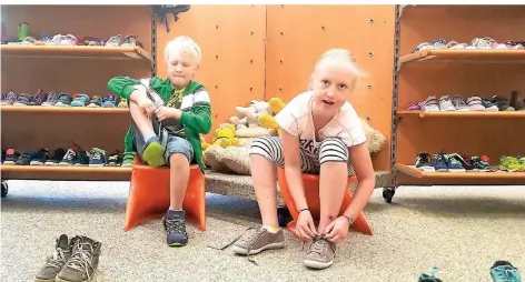  ?? FOTOS: (3) STEPHAN BÜLLESBACH ?? Zoey (9) und Joe (7) probieren im Schuhhaus Albus Schuhe an. Die Geschwiste­r sind mit ihren Eltern extra aus Wipperfürt­h gekommen.