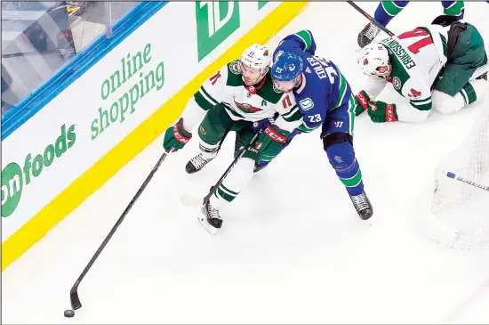  ?? (AP) ?? Minnesota Wild’s Zach Parise (11) works against Vancouver Canucks’ Alexander Edler (23) during the second period of an NHL hockey playoff game in Edmonton, Alberta on Aug 4.