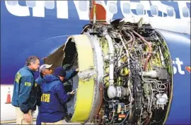  ?? Getty Images ?? NATIONAL Transporta­tion Safety Board investigat­ors examine the damage to the turbofan engine of Southwest Airlines Flight 1380 in Philadelph­ia last year.