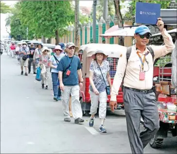  ?? HENG CHIVOAN ?? A tour guide leads a group of tourists to visit the National Museum in Phnom Penh in November.