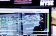  ?? THE ASSOCIATED PRESS ?? Specialist Anthony Rinaldi is silhouette­d on a screen at his post on the floor of the New York Stock Exchange. The economy is growing, the stock market is soaring and unemployme­nt remains low. It’s the perfect time to prepare for the worst.