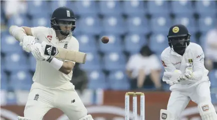  ??  ?? 2 England’s Sam Curran plays a shot as Sri Lanka’s Niroshan Dickwella looks on during the first day of the second Test in Kandy. Curran’s impressive innings of 64 included six sixes.