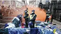  ?? Hollie Adams / Getty Images ?? Activists throw NHS uniforms at police officers outside Downing Street on Saturday in London.