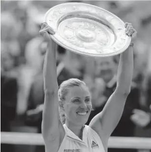  ?? Ben Curtis, The Associated Press ?? Angelique Kerber lifts the trophy after winning the Wimbledon women’s singles final match against Serena Williams in London on Saturday.