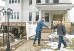  ?? ANDY LAVALLEY/POST-TRIBUNE ?? Re/Max Lifestyles broker/owner Matt Evans, left, greets Mike Gonzalez outside the Benton House at 607 Lincolnway Ave. in Valparaiso on Feb. 16. Gonzales stopped by to check on possible uses for the home up for sale at $599,000.