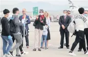  ??  ?? British ambassador to Greece, Kate Smith, centre, greets migrants from overcrowde­d camps at Athens Internatio­nal Airport yesterday.