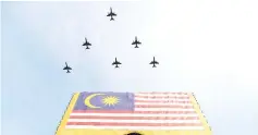  ?? - Bernama photo ?? Royal Malaysian Air Force aircraft flying past the Putrajaya air space during the National Day celebratio­n at Dataran Putrajaya yesterday.