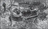  ??  ?? ZOO CRASH: Police investigat­e the destroyed van that plunged over the Bronx River Parkway on Sunday in New York. Authoritie­s say the out- of- control van plunged off a roadway near the Bronx Zoo, killing seven people, including three children.