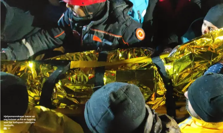  ?? AP ?? Hjelpemann­skaper baerer en ung kvinner ut fra en bygning som har kollapset i storbyen Sanliurfa.