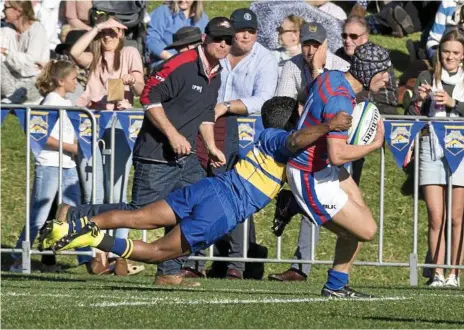  ?? Photos: Nev Madsen ?? TRY TIME: Downlands winger Jasper Curran scores a try despite a desperate effort by Allister Cameron. Downlands 27-21 victory on Saturday bought an end to Toowoomba Grammar School’s five game O’Callaghan Cup winning streak.