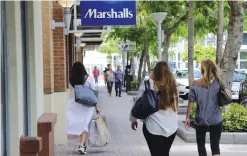 ??  ?? MIAMI: Shoppers walk past a Marshalls store in Miami. Consumer spending slowed in June as income growth turned in the weakest performanc­e in seven months, according to informatio­n released yesterday.—AP