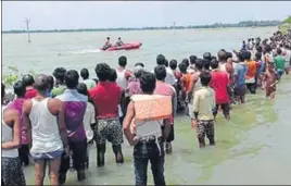  ??  ?? People in Bihar’s floodhit Bhagalpur district await evacuation on Sunday.