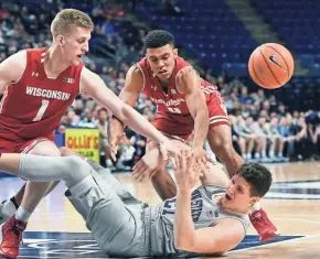  ?? ASSOCIATED PRESS ?? Wisconsin guards Brevin Pritzl (left) and D'Mitrik Trice and Penn State forward John Harrar fight for a loose ball Monday night.