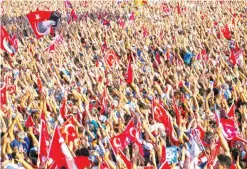  ?? — AFP ?? ISTANBUL: People wave Turkish flags and portraits of modern Turkey’s founding father Mustafa Kemal Ataturk, during a rally yesterday in Taksim Square.