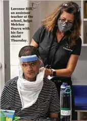  ?? Bob Owen / San Antonio Express-News ?? Lavonne Hill, an assistant teacher at the school, helps Melchor Ibarra with his face shield Thursday.