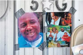  ?? [AP FILE PHOTO] ?? Photos of Alton Sterling are taped to the wall at a makeshift memorial outside the Triple S convenienc­e store July 6, 2016 in Baton Rouge, La. Sterling was shot and killed by Baton Rouge police outside the store where he was selling CDs.