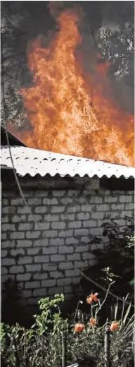  ?? // AFP ?? Una anciana se aleja de una casa en llamas en Lisichansk