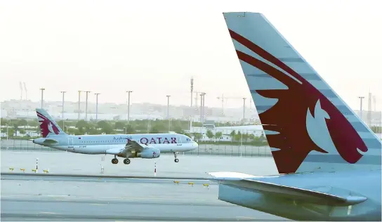  ??  ?? A Qatar Airways plane lands at Hamad Internatio­nal Airport in Doha. (AFP)