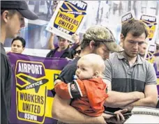  ??  ?? AMONG THE changes that President-elect Donald Trump is expected to make is to the makeup of the National Labor Relations Board. Above, travelers at LAX check in as demonstrat­ors march by.