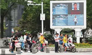  ??  ?? Person of interest: An electronic billboard displaying the picture of a man found jaywalking. — China Daily/Asia News Network