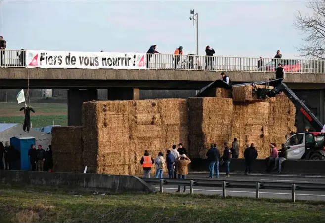  ?? ?? »Vi er stolte over at give dig mad,« står der på et banner over en af de motorveje ind mod Paris, som mandag blev blokeret af landmaend. Foto: Bertrand Guay/AFP