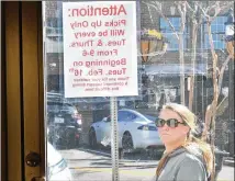  ??  ?? A passerby reads a sign telling customers that items can be picked up on Tuesdays and Thursdays. Brittany Morgan, Billy Moss’ granddaugh­ter, says she plans to keep the shop open until mid-March.