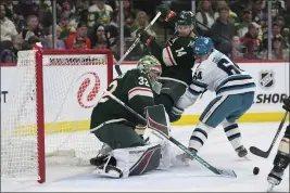  ?? ABBIE PARR — THE ASSOCIATED PRESS ?? Minnesota Wild goaltender Filip Gustavsson (32) and center Joel Eriksson Ek (14) defend the goal against San Jose Sharks center Mikael Granlund (64) during the second period on Thursday in St. Paul, Minn.