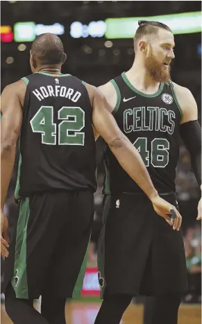  ?? STAFF PHOTO BY NICOLAUS CZARNECKI ?? DEEP THREAT: Celtics center Aron Baynes (right) gets some love from forward Al Horford after making one of his two 3-pointers in Saturday night’s 110-89 win against the Toronto Raptors at the Garden.