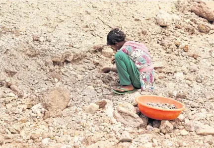 ??  ?? LEFT
A 13-year-old girl breaks away pieces of mica from rocks in an illegal open-cast mine in Koderma district in the eastern state of Jharkhand in India in 2016.